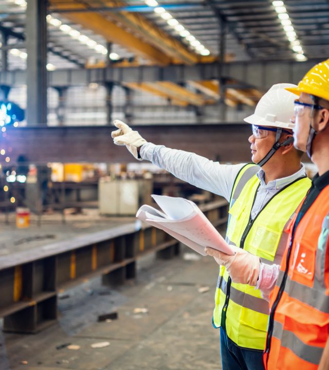 Quality inspectors working in a steel factory.